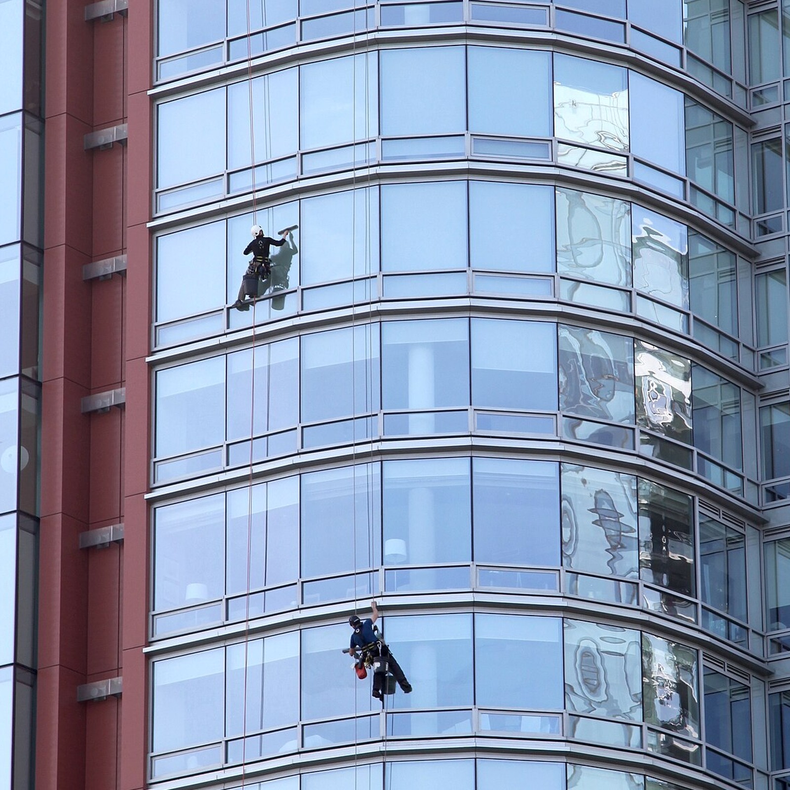 Certified rope access technicians cleaning a Vancouver high-rise glass facade